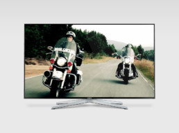 Photograph of two motor bikers riding in the countryside on a Samsung monitor